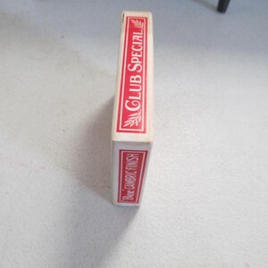 May include: A red and white box of Bee playing cards with the text "Club Special" and "Bee Cambric Finish" printed on the side.