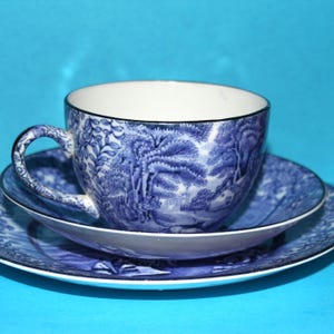以下が含まれることがあります： 青い花柄のティーカップとソーサーのセット。カップとソーサーは繊細でヴィンテージな雰囲気です。