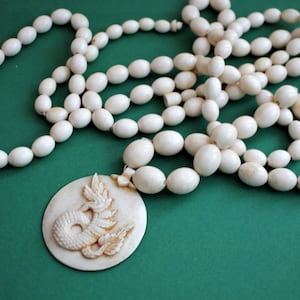A vintage hand carved Beaded Bovine Dragon Necklace/Length approx. 6ft in length.