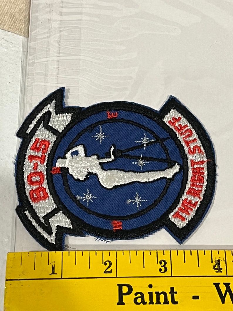 Pu&ograve; includere: Una toppa ricamata blu e bianca con una silhouette bianca di una persona con il paracadute, circondata da stelle bianche. Il testo "GO-15" &egrave; sul lato sinistro della toppa e "THE GREAT STUFF" &egrave; sul lato destro.