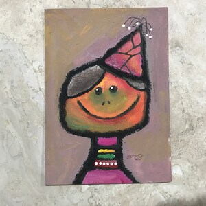 May include: A colorful painting of a smiling person wearing a pink and purple party hat with white decorations. The person has a green and orange face with black eyes and a black outline. The person is wearing a pink shirt with a yellow, green, and white striped collar and a white beaded necklace.