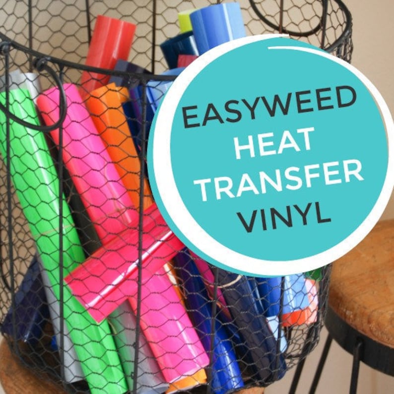 K&ouml;nnte beinhalten: Ein Drahtkorb gef&uuml;llt mit Rollen EasyWeed Heat Transfer Vinyl in verschiedenen Farben, darunter Gr&uuml;n, Pink, Orange, Rot und Blau. Der Korb steht auf einem Holzhocker. Der Text "EASYWEED HEAT TRANSFER VINYL" ist in Wei&szlig; auf einem t&uuml;rkisfarbenen Kreis geschrieben.