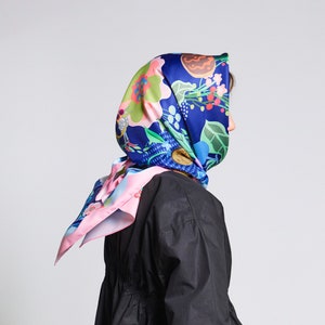 May include: A black long-sleeved dress with a gathered waist and a floral print headscarf.