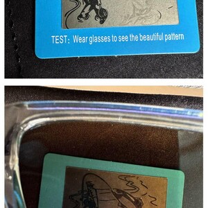 K&ouml;nnte beinhalten: Eine blaue rechteckige Karte mit einem silbernen Bild eines Fischers und eines Fisches. Der Text "TEST: Wear glasses to see the beautiful pattern" ist auf die Karte gedruckt. Die Karte liegt auf einer dunklen Oberfl&auml;che.