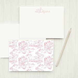 May include: A set of personalized stationery featuring a pink and white design with a repeating pattern of children playing with a pig. The top sheet has the name "catherine" written in pink cursive.
