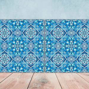 May include: Two blue and white patterned square tiles with intricate floral designs. The tiles are arranged side by side against a light blue background.