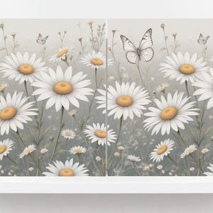 May include: A floral print featuring white daisies with yellow centres and butterflies against a soft grey background. The artwork is displayed on a white shelf, creating a serene and natural aesthetic.
