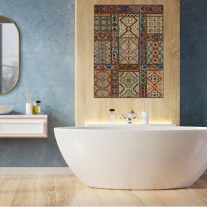 May include: A white bathtub with a tiled wall behind it. The tiles are a mix of colors and patterns, including red, blue, green, and yellow. The bathtub is in a bathroom with a wooden floor.