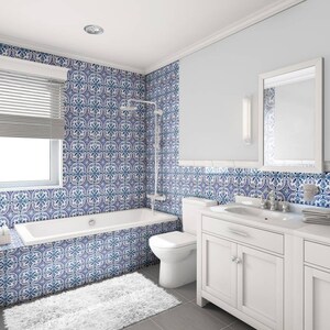 Puede incluir: Un ba&ntilde;o blanco con paredes de azulejos con patrones azules y blancos, una ba&ntilde;era blanca, un tocador blanco con dos lavabos y dos espejos.
