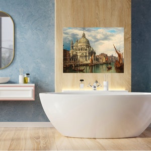 May include: A white bathroom with a freestanding bathtub, a sink with a mirror, and a painting of a cityscape with a church in the background.
