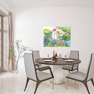 May include: A dining room featuring a round wooden table set for a meal. Four chairs with patterned backs surround the table. A painting of pink lotus flowers and green leaves hangs on the wall. A window with pink curtains is on the left.