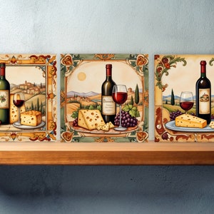 May include: Three decorative ceramic tiles with a rustic Italian countryside theme. Each tile features a bottle of red wine, a glass of red wine, a wedge of cheese, and grapes. The tiles are framed with ornate gold and green borders.