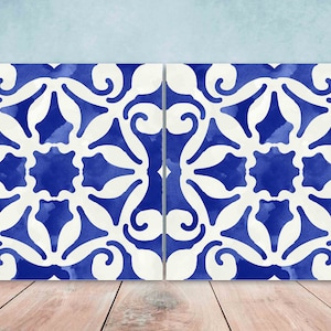 Könnte beinhalten: Zwei blaue und weiße Keramikfliesen mit einem sich wiederholenden geometrischen Muster. Die Fliesen sind nebeneinander angeordnet und haben einen Aquarelleffekt.