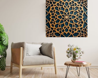 May include: A gold and blue geometric wall art piece with a intricate mandala design. The art piece is hanging on a white wall above a light gray armchair and a wooden side table with a vase of white flowers.