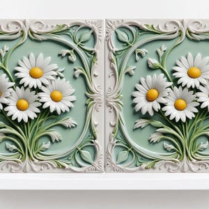 May include: Two decorative ceramic tiles featuring a raised design of white daisies with yellow centres on a light green background. The tiles are framed with a white ornate design.