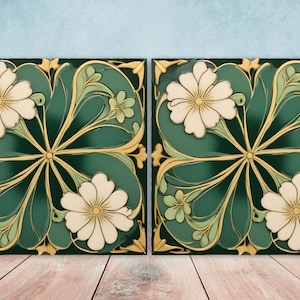 May include: Two green ceramic tiles with a white floral design. The tiles have a gold trim and are decorated with stylized flowers and leaves.