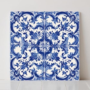 May include: Square ceramic tile with a repeating blue and white floral pattern. The design features stylized flowers and leaves in varying shades of blue against a white background. The tile is likely for home decor.