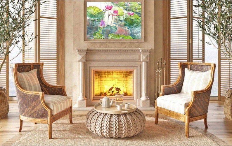 May include: A comfortable living room with a fireplace, adorned with a framed painting of lotus flowers. Two wicker armchairs with striped cushions are positioned on either side. A round ottoman with a tray and tea set is placed in front of the fireplace.