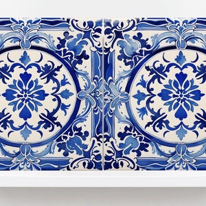 Può includere: Due piastrelle quadrate in ceramica con un design floreale blu e bianco. Ogni piastrella presenta un motivo circolare centrale con un motivo floreale simmetrico, circondato da ornati riccioli blu su sfondo crema. Le piastrelle sono esposte su una mensola bianca.