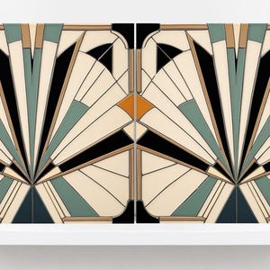 Puede incluir: Dos paneles cuadrados de estilo art déco con un diseño de abanico. Los paneles presentan un fondo crema con formas geométricas negras, verde azulado, beige y naranja. Los paneles se exhiben en una estantería blanca.