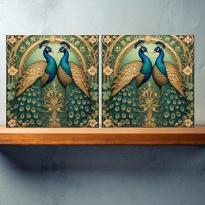 May include: Two peacocks with gold and green plumage face each other in a decorative art nouveau style frame. The peacocks have blue and green feathers on their necks and tails.