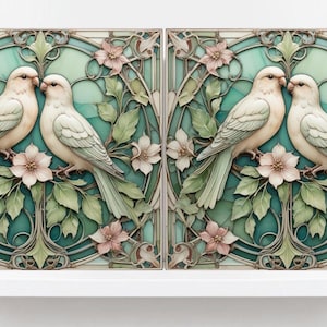 May include: Two white birds with pink accents are perched on a branch with green leaves and pink flowers. The birds are facing each other and their beaks are touching. The background is a teal blue with a stained glass design.