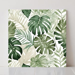 Op de afbeelding: Vierkante canvas kunst met een aquarelontwerp van tropische bladeren in tinten groen en beige tegen een witte achtergrond. De bladeren omvatten monstera, palm en ander tropisch gebladerte, waardoor een weelderig, botanisch patroon ontstaat.