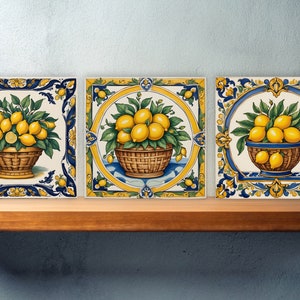 May include: Three square ceramic tiles with a blue and yellow border and a white background. Each tile features a basket of lemons with green leaves.