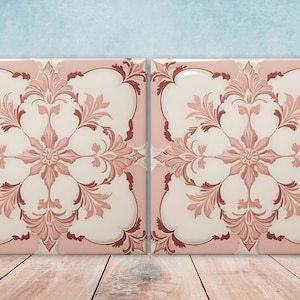 May include: Two pink ceramic tiles with a white centre and a floral design in shades of pink and brown.
