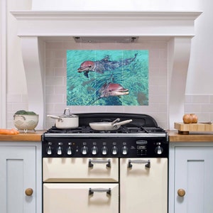 May include: A kitchen backsplash with a tile design featuring two dolphins swimming in turquoise water.