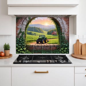 Puede incluir: Un protector contra salpicaduras de cocina con un paisaje de granja escénico. La imagen muestra un tractor verde en un camino de tierra, campos, un granero rojo y una puesta de sol enmarcada por un arco de ladrillo cubierto de hiedra. La escena evoca tranquilidad rural.