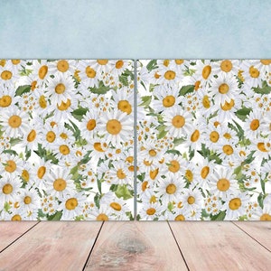May include: Two white canvases with a pattern of white daisies with yellow centres on a white background.