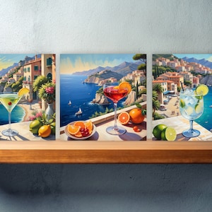 Puede incluir: Tres pinturas que representan una ciudad costera italiana, cada una con un cóctel diferente en primer plano. La primera pintura presenta un martini con una cereza, la segunda un vaso de vino tinto con una rodaja de naranja y la tercera un gin tonic con una rodaja de lima.