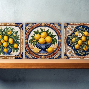 May include: Three square ceramic tiles with ornate gold and blue frames. Each tile features a different depiction of lemons, with one showing a bowl of lemons, another a lemon tree with fruit, and the third a lemon branch with blossoms.