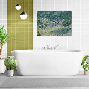 Può includere: Una vasca da bagno bianca con un rubinetto cromato e un dipinto di un paesaggio con alberi e un fiume sopra. Il bagno ha pareti piastrellate di verde e bianco e un tappetino da bagno grigio sul pavimento. Ci sono due piante in vaso sul pavimento.