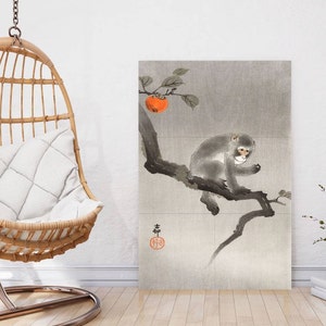 Könnte beinhalten: Ein traditionelles japanisches Gemälde, das einen Affen auf einem Ast eines Baumes mit einer Kaki-Frucht zeigt. Das Gemälde ist in Grautönen und Schwarz gehalten, mit einem Hauch von Orange für die Frucht.
