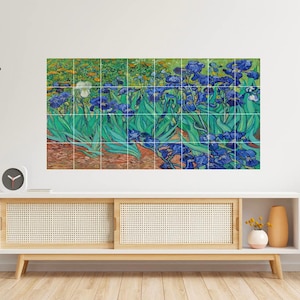 May include: A wall art print of a painting of a field of blue irises with green leaves and a white iris in the background. The painting is divided into squares, giving it a tiled effect.
