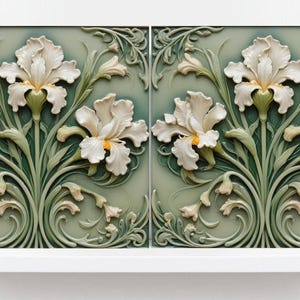 May include: Two ceramic tiles with a raised design of white iris flowers on a green background. The tiles are framed in white.