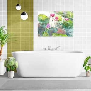May include: A contemporary bathroom featuring a white bathtub, a grey rug, and potted plants. A watercolour painting of pink lotus flowers and green leaves hangs above the tub. The walls are white with a grid pattern, and there are hanging globe lights.