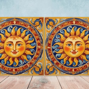 Könnte beinhalten: Zwei quadratische Keramikfliesen mit einem lächelnden Sonnendesign. Die Sonne hat ein gelbes Gesicht mit blauen Augen und roten Wangen, umgeben von gelben Flammen. Die Fliesen haben einen blauen und roten kreisförmigen Rand mit dekorativen Elementen.