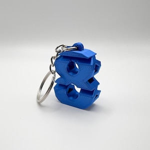 May include: A blue 3D printed keychain shaped like the number eight. The keychain has a silver metal ring.