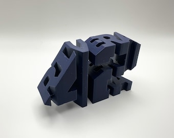 May include: A navy blue 3D-printed sculpture spelling out the word "ART". The letters are interconnected and arranged in a dynamic, abstract composition. The sculpture is set against a plain white background.
