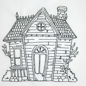 Pode incluir: Um desenho a preto e branco de uma pequena casa com um telhado de duas &aacute;guas, uma chamin&eacute; e uma porta com uma janela. A casa tem um exterior de tijolo e um telhado de telhas. H&aacute; &aacute;rvores e arbustos em volta da casa.