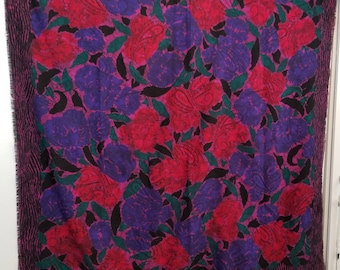 May include: A square patterned scarf with a floral design. The scarf features a pink background with red and purple flowers and black leaves.