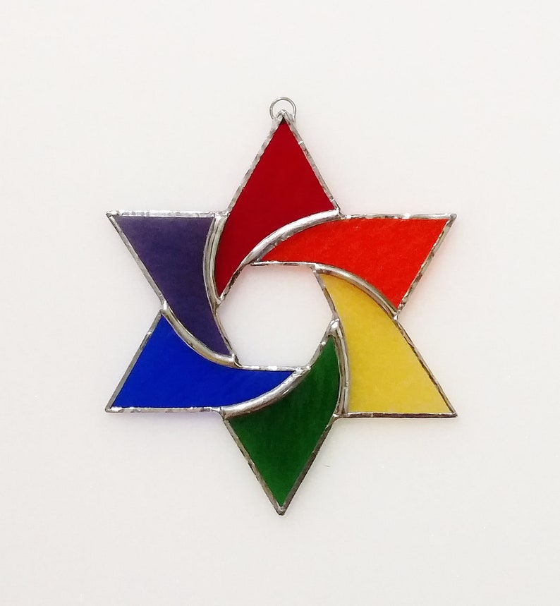 Pu&ograve; includere: Un ornamento a forma di Stella di David in vetro colorato con un design arcobaleno. La stella &egrave; composta da sei punte ed &egrave; decorata con vetro rosso, arancione, giallo, verde, blu e viola.