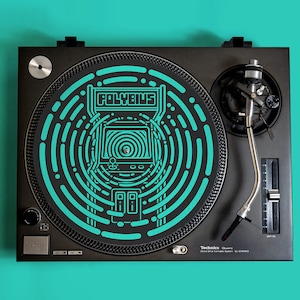 May include: A black turntable with a teal and black Polybius arcade game themed slipmat. The turntable is a Technics SL-1200MK2.