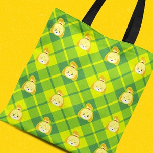 Peut inclure: Un sac fourre-tout vert et jaune à motif écossais avec une image répétée d'un chien de dessin animé aux oreilles brunes et au nez jaune.
