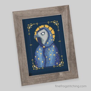 Pode incluir: Arte em ponto cruz de um p&aacute;ssaro vestindo uma t&uacute;nica azul com estrelas douradas e uma aur&eacute;ola dourada, emoldurada em uma moldura de madeira cinza. O p&aacute;ssaro tem uma cabe&ccedil;a cinza e um olho branco. O fundo &eacute; azul escuro. O site finefrogstitching.com &eacute; vis&iacute;vel.