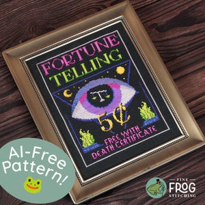 May include: A framed cross-stitch piece on black fabric featuring the text FORTUNE TELLING in pink and green, a large purple eye with a scale symbol, the text 5 cents, and the text FREE WITH DEATH CERTIFICATE in pink.
