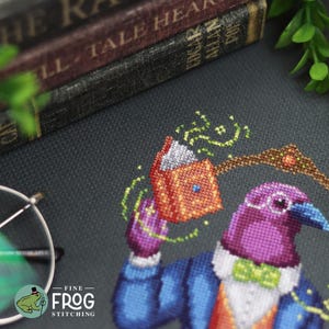 May include: A cross-stitch embroidery on dark fabric featuring a purple bird wearing a blue suit, white shirt, and green bow tie. The bird holds an open orange book with glowing green magical effects. A brown arch is visible above the bird.